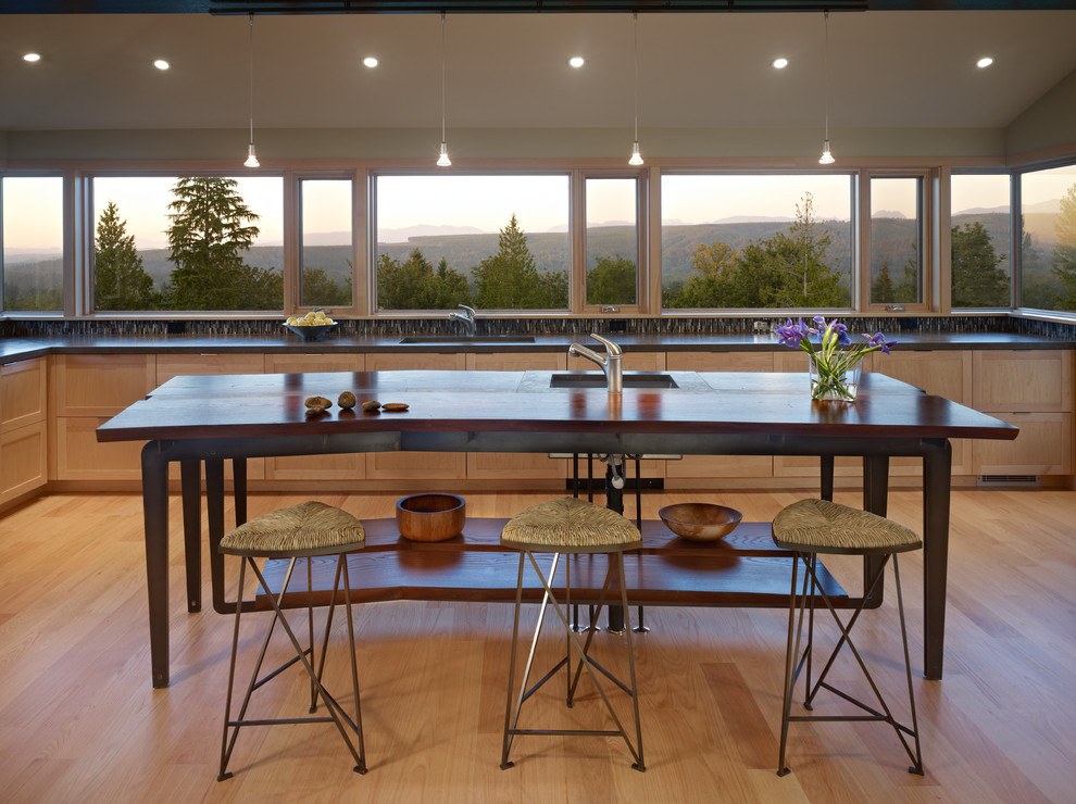 Immagine di una cucina minimalista di medie dimensioni con lavello sottopiano, ante in stile shaker, ante in legno chiaro, top in pietra calcarea, elettrodomestici da incasso e parquet chiaro