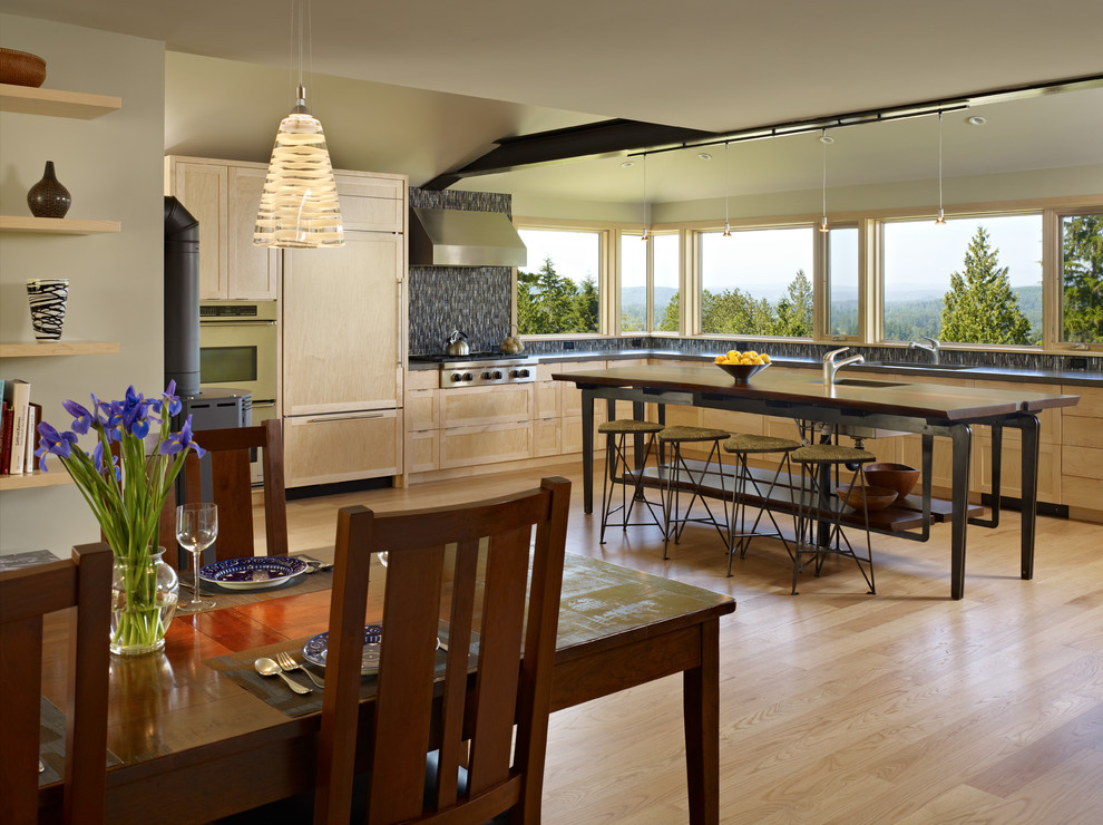 Foto di una cucina minimalista di medie dimensioni con ante in stile shaker, ante in legno chiaro, top in pietra calcarea, elettrodomestici da incasso e parquet chiaro