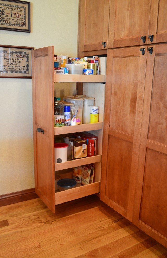 Inspiration for a large traditional l-shaped kitchen pantry in Denver with shaker cabinets and light wood cabinets.
