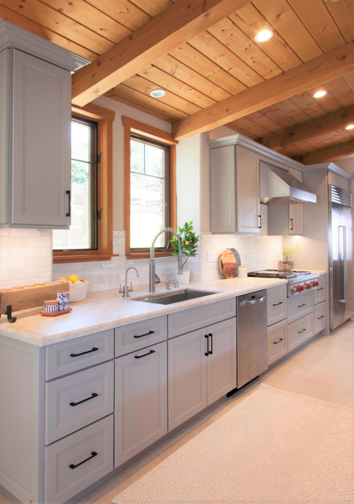 Exempel på ett stort rustikt vit vitt kök, med en undermonterad diskho, luckor med infälld panel, grå skåp, bänkskiva i kvartsit, vitt stänkskydd, stänkskydd i cementkakel, rostfria vitvaror, klinkergolv i porslin, en köksö och grått golv