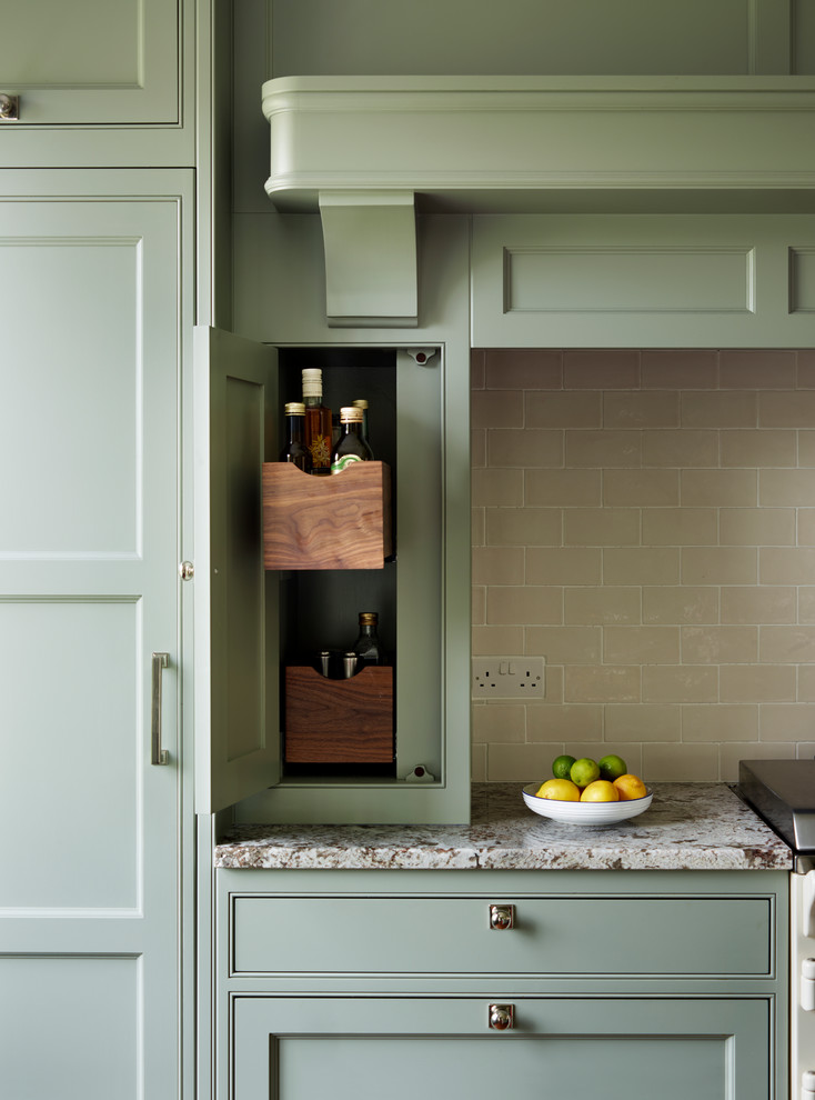 Foto de cocina comedor clásica grande con una isla, puertas de armario verdes, encimera de granito, salpicadero beige, salpicadero de azulejos tipo metro y electrodomésticos con paneles