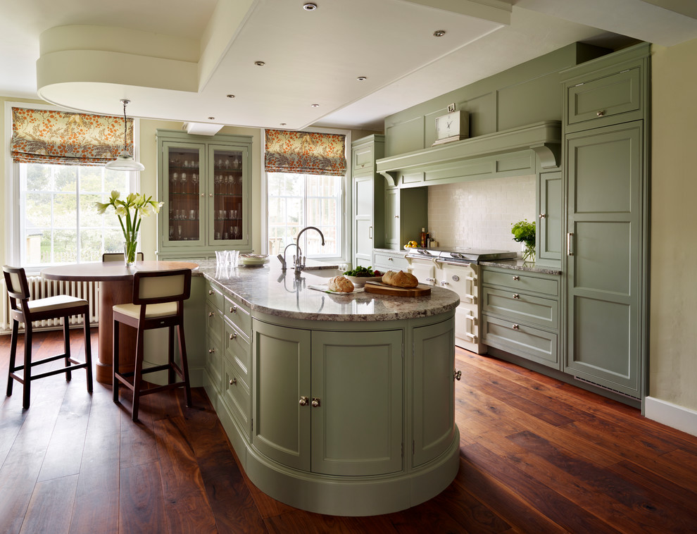 エセックスにある高級な広いトラディショナルスタイルのおしゃれなキッチン (緑のキャビネット、御影石カウンター、ベージュキッチンパネル、サブウェイタイルのキッチンパネル、パネルと同色の調理設備、濃色無垢フローリング) の写真