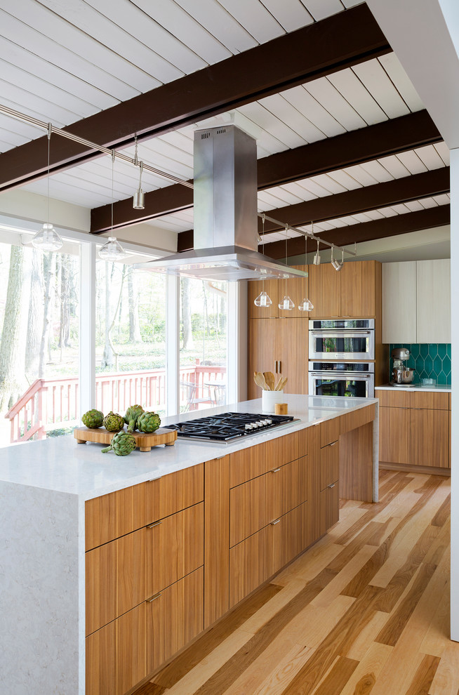 Large contemporary open plan kitchen in DC Metro with flat-panel cabinets, medium wood cabinets, blue splashback, stainless steel appliances, medium hardwood flooring and an island.