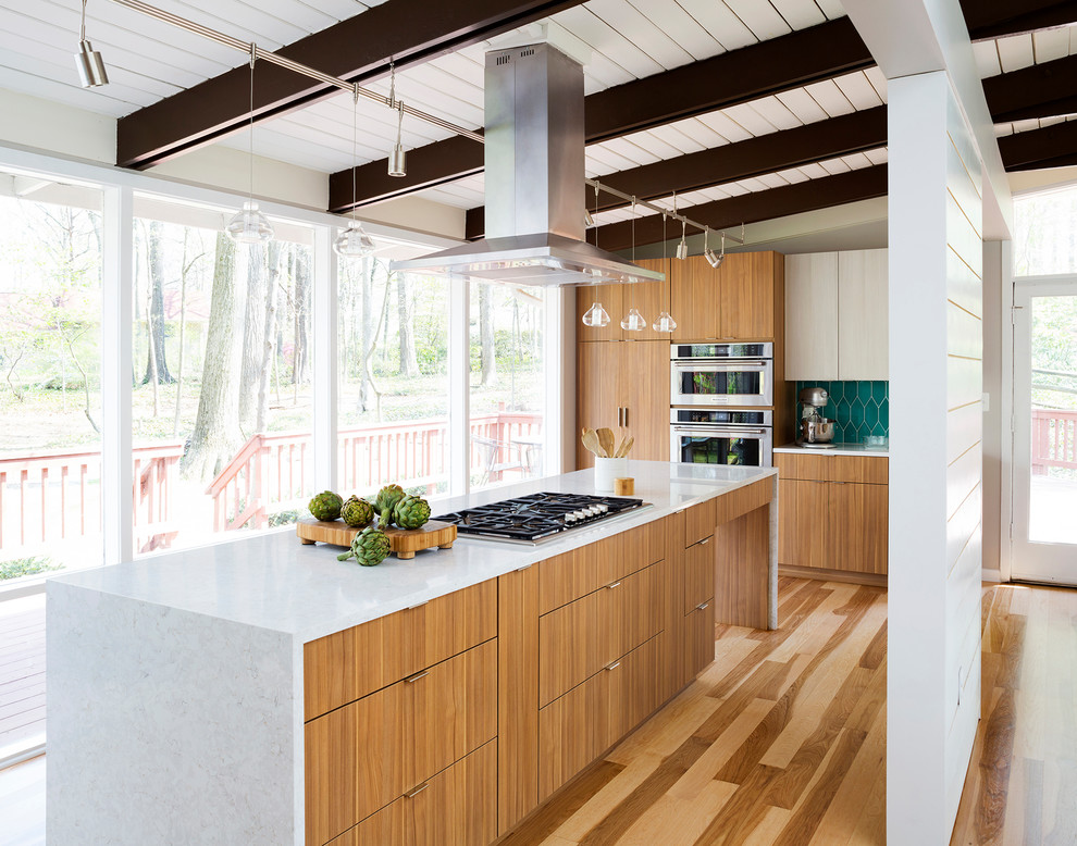 Immagine di una grande cucina contemporanea con ante lisce, ante in legno scuro, paraspruzzi blu, elettrodomestici in acciaio inossidabile e pavimento in legno massello medio