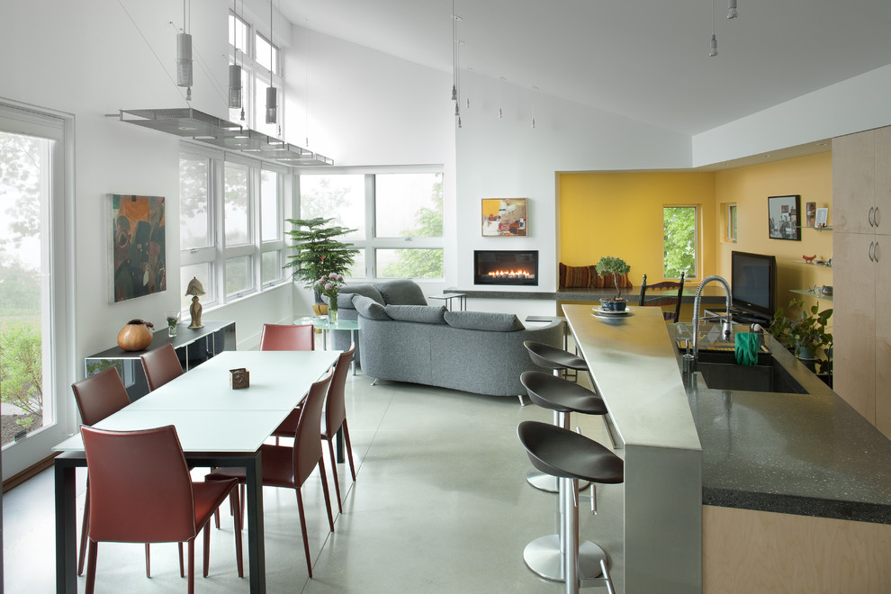 Immagine di una cucina contemporanea con ante lisce, ante in legno chiaro, lavello sottopiano e pavimento in cemento