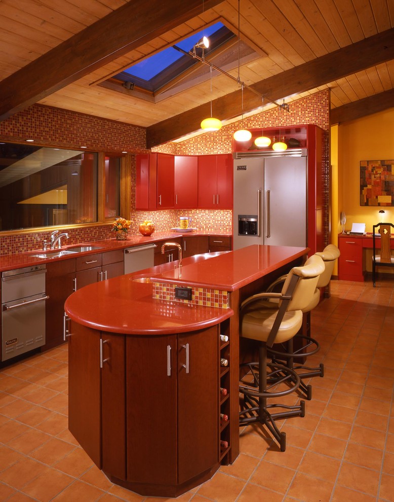 ポートランド(メイン)にある高級な広いモダンスタイルのおしゃれなキッチン (フラットパネル扉のキャビネット、赤いキャビネット、クオーツストーンカウンター、マルチカラーのキッチンパネル、ガラスタイルのキッチンパネル、カラー調理設備、テラコッタタイルの床、アンダーカウンターシンク) の写真