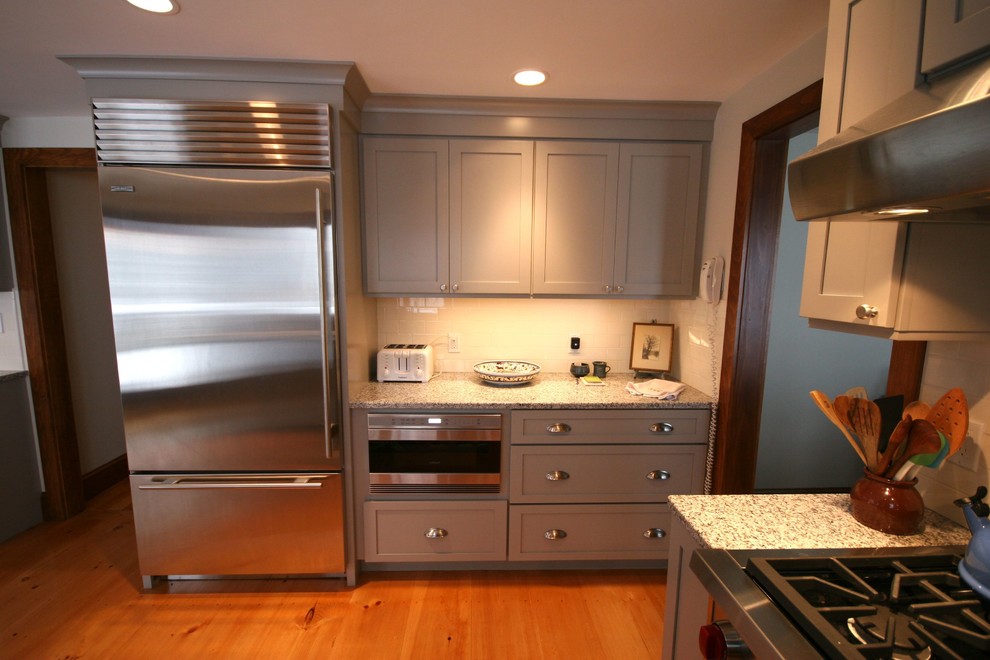 Inspiration for a cottage kitchen remodel in Boston with an undermount sink, shaker cabinets, gray cabinets, granite countertops and white backsplash