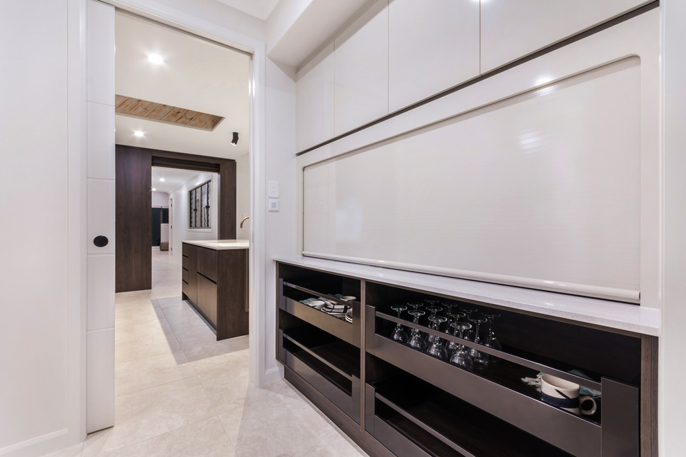Immagine di una grande cucina minimalista con lavello a doppia vasca, ante in legno bruno, paraspruzzi bianco, elettrodomestici in acciaio inossidabile, pavimento con piastrelle in ceramica, pavimento beige e top bianco