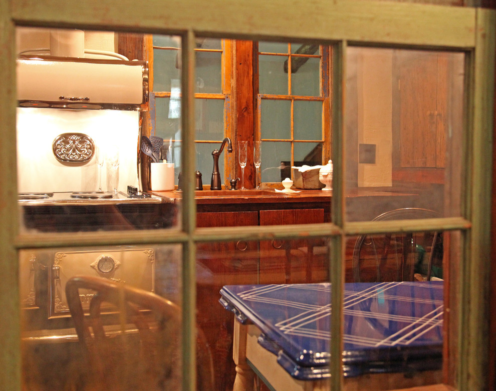 Foto di una piccola cucina lineare rustica chiusa con lavello sottopiano, ante lisce, ante in legno scuro, top in legno, elettrodomestici colorati e pavimento in legno massello medio