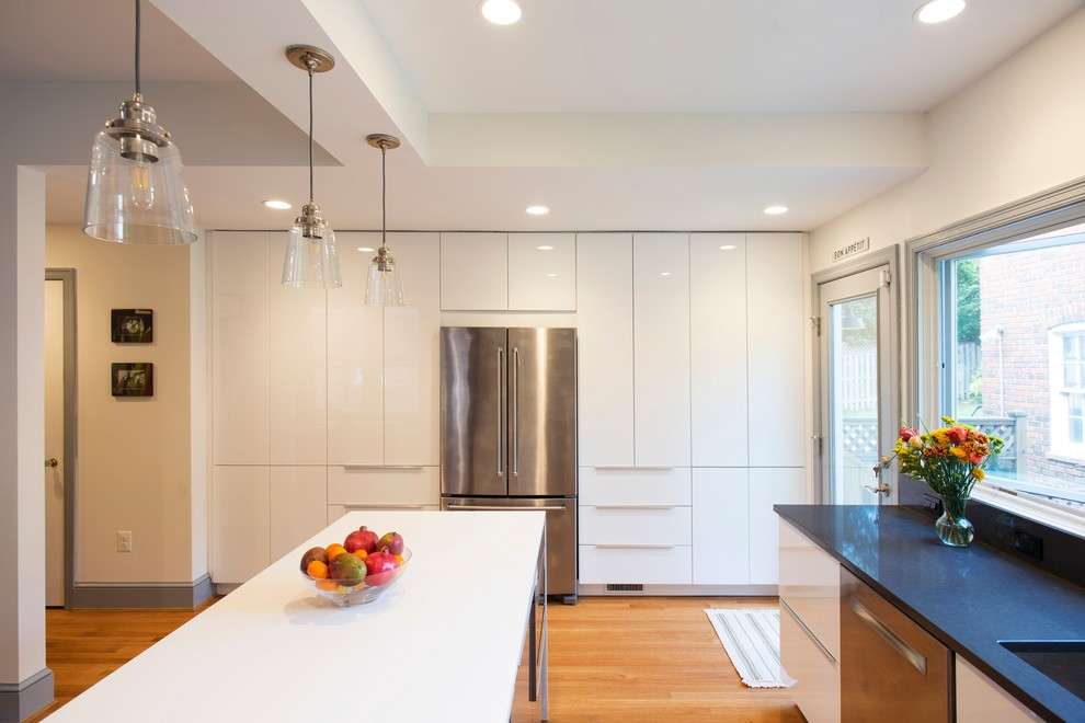 Inspiration for a medium sized modern u-shaped kitchen/diner in DC Metro with a submerged sink, flat-panel cabinets, white cabinets, engineered stone countertops, stainless steel appliances, medium hardwood flooring and an island.