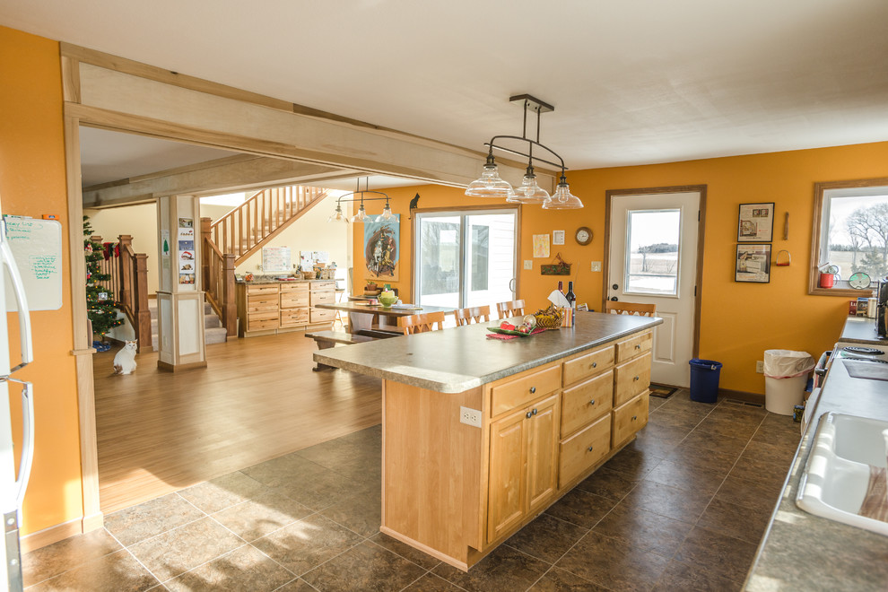 Offene, Mittelgroße Klassische Küche in L-Form mit profilierten Schrankfronten, hellen Holzschränken, Laminat-Arbeitsplatte, Vinylboden und Kücheninsel in Sonstige