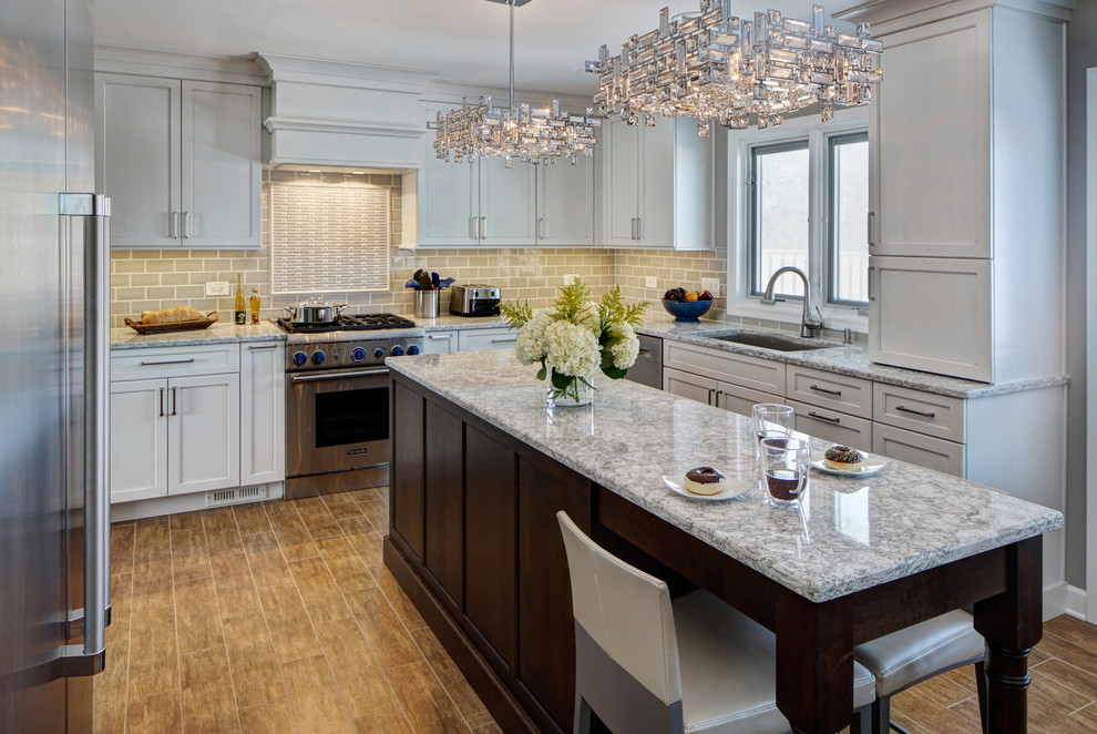 Inspiration for a mid-sized transitional u-shaped porcelain tile eat-in kitchen remodel in Chicago with an undermount sink, shaker cabinets, white cabinets, quartz countertops, gray backsplash, ceramic backsplash, stainless steel appliances and an island