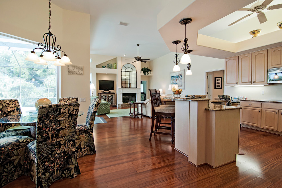 Immagine di una cucina ad ambiente unico chic con lavello sottopiano, top in granito, elettrodomestici in acciaio inossidabile e pavimento in legno massello medio