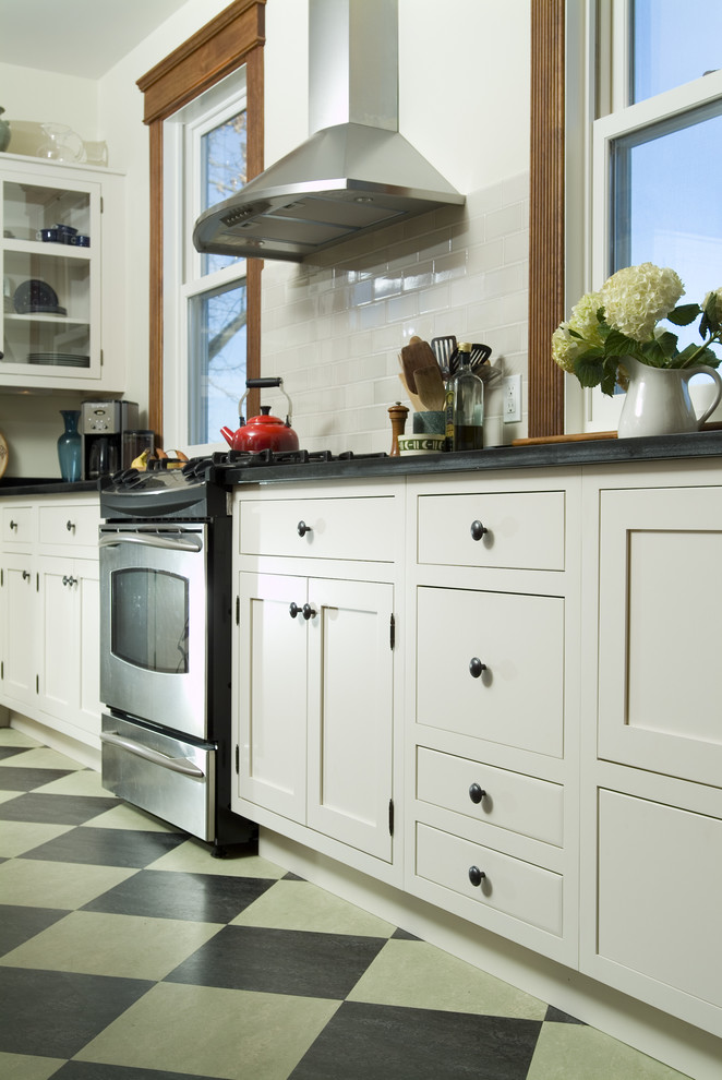 Exempel på ett stort lantligt kök, med en dubbel diskho, skåp i shakerstil, vita skåp, bänkskiva i täljsten, stänkskydd i sten, rostfria vitvaror, linoleumgolv och en köksö