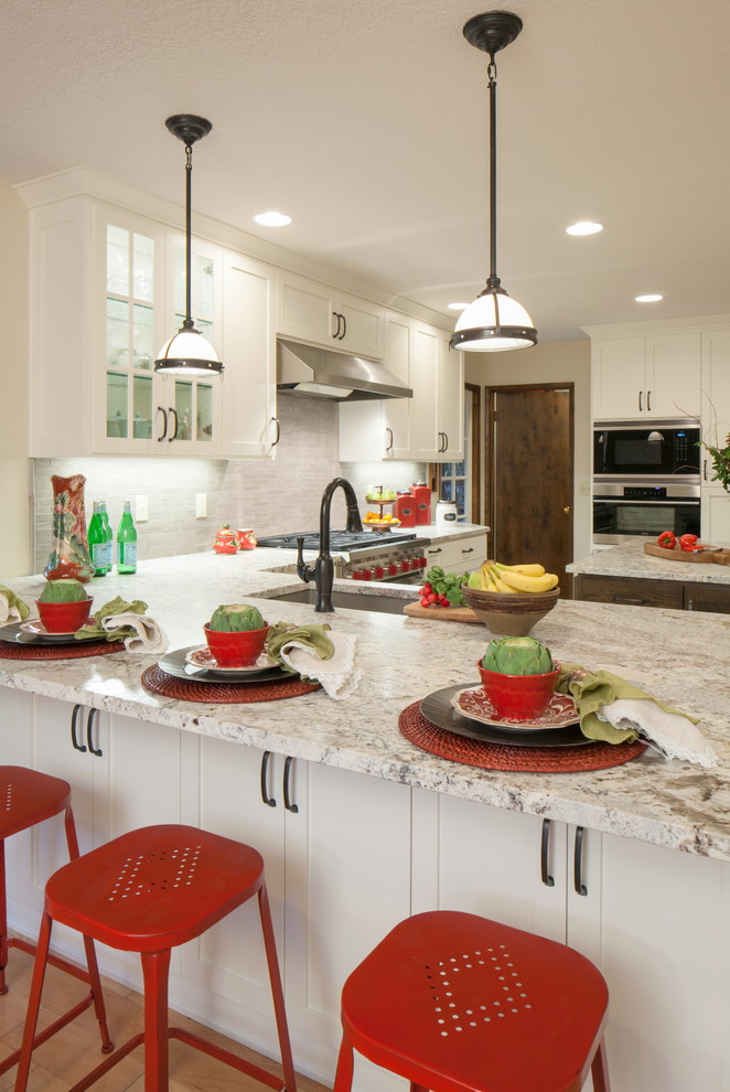 На фото: п-образная кухня в классическом стиле с врезной мойкой, фасадами в стиле шейкер, белыми фасадами, серым фартуком и островом