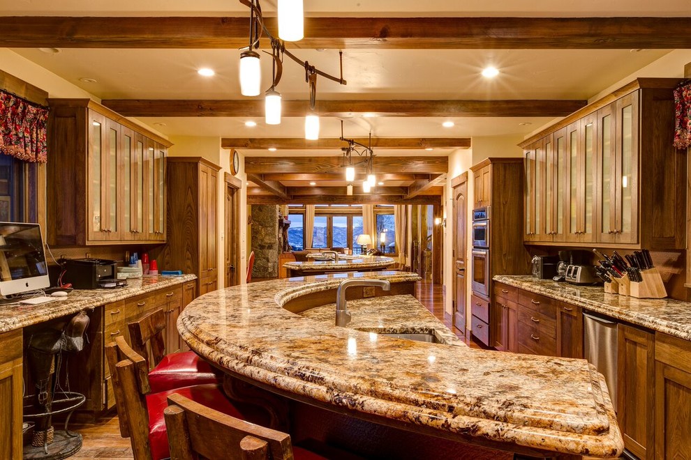 This is an example of a large rustic kitchen in Denver with a submerged sink, shaker cabinets, medium wood cabinets, granite worktops, red splashback, integrated appliances, medium hardwood flooring and an island.