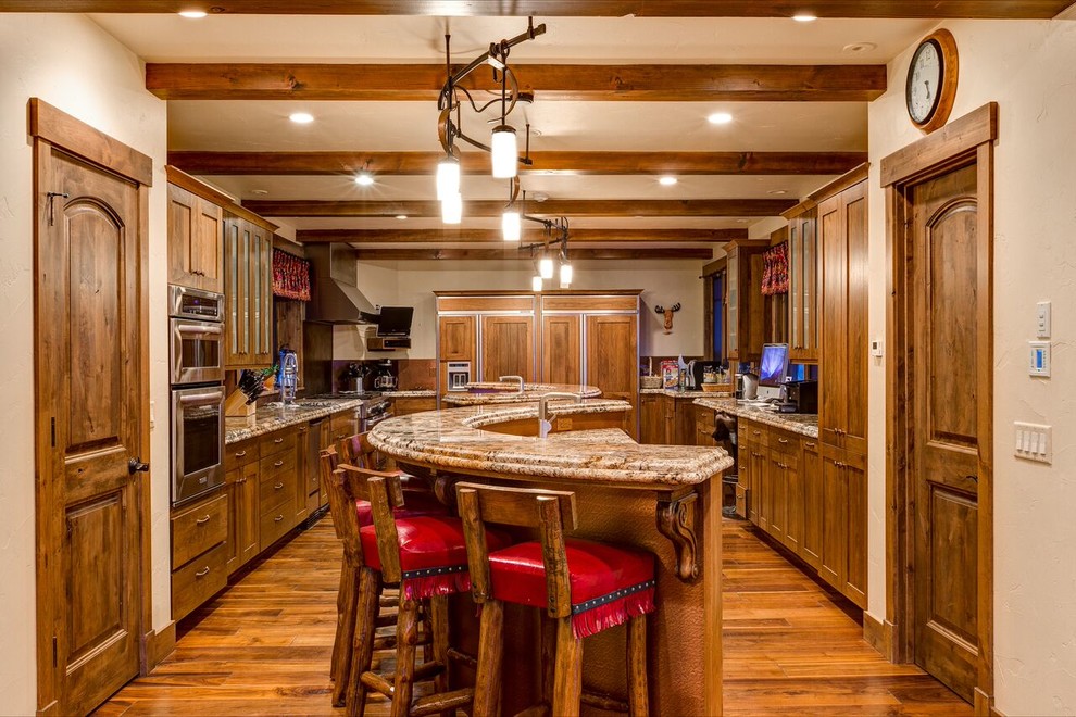 Enclosed kitchen - large rustic u-shaped medium tone wood floor and brown floor enclosed kitchen idea in Denver with an undermount sink, shaker cabinets, medium tone wood cabinets, granite countertops, red backsplash, paneled appliances and an island
