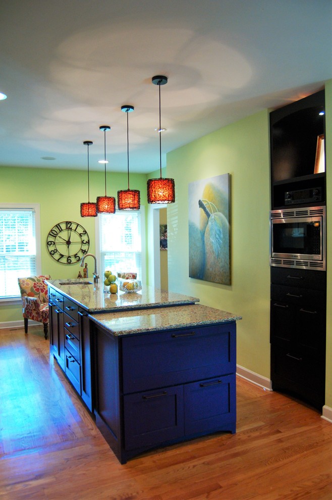 Inspiration for a large eclectic galley light wood floor eat-in kitchen remodel in Nashville with an undermount sink, shaker cabinets, blue cabinets, recycled glass countertops, yellow backsplash, glass sheet backsplash, stainless steel appliances and an island