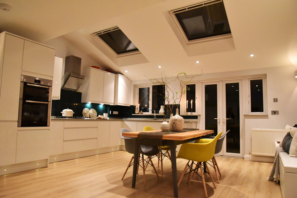 Inspiration for a medium sized contemporary open plan kitchen in London with laminate floors.