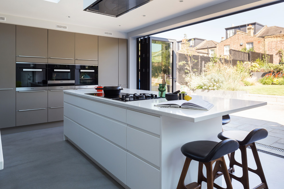 Design ideas for a retro open plan kitchen in London with concrete flooring and an island.