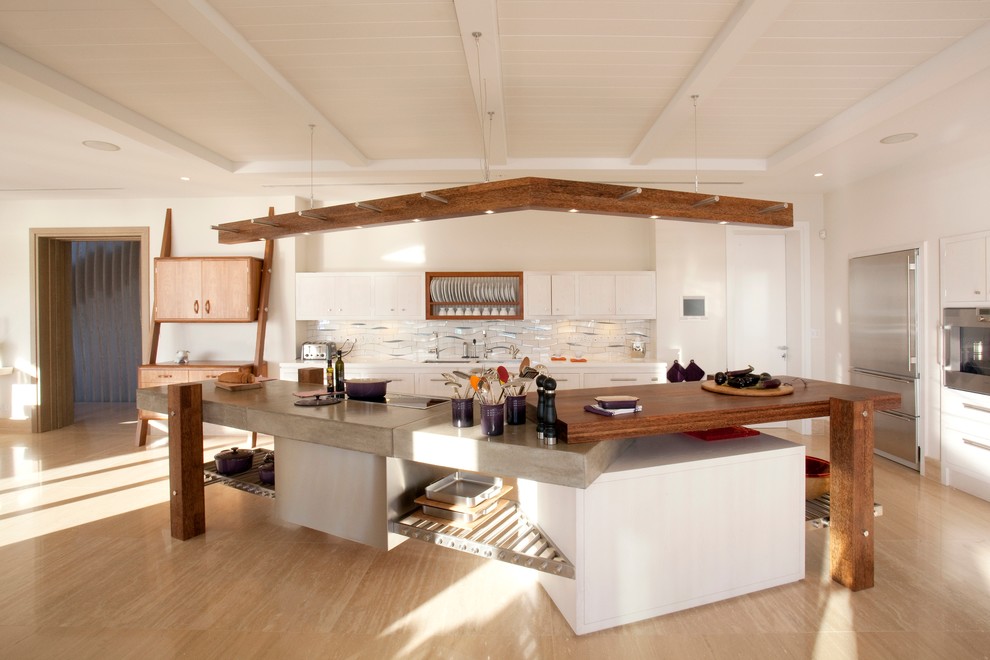 Exempel på ett stort maritimt kök, med en undermonterad diskho, vita skåp, bänkskiva i betong, stänkskydd i keramik, rostfria vitvaror, travertin golv och en köksö