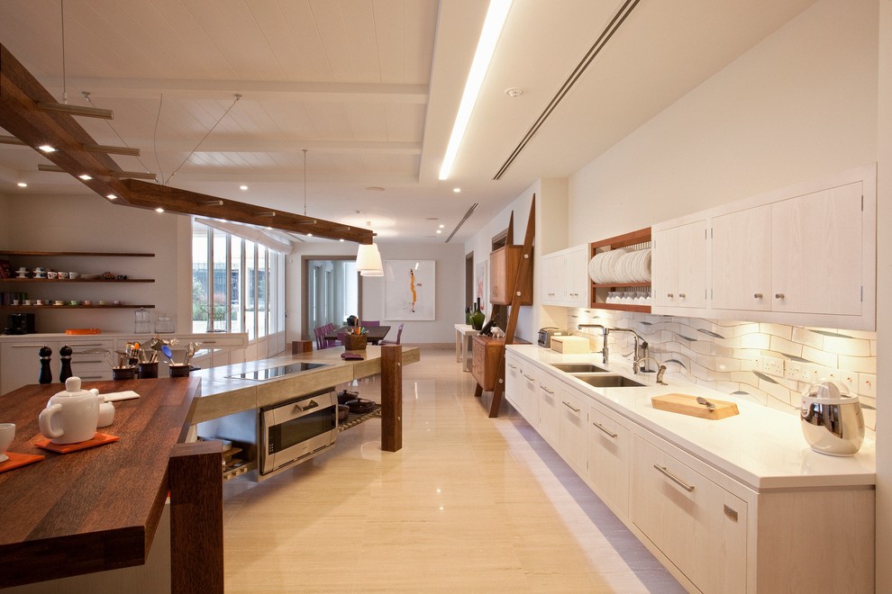 Large trendy travertine floor kitchen photo in Other with an undermount sink, ceramic backsplash, an island, flat-panel cabinets, light wood cabinets and white backsplash