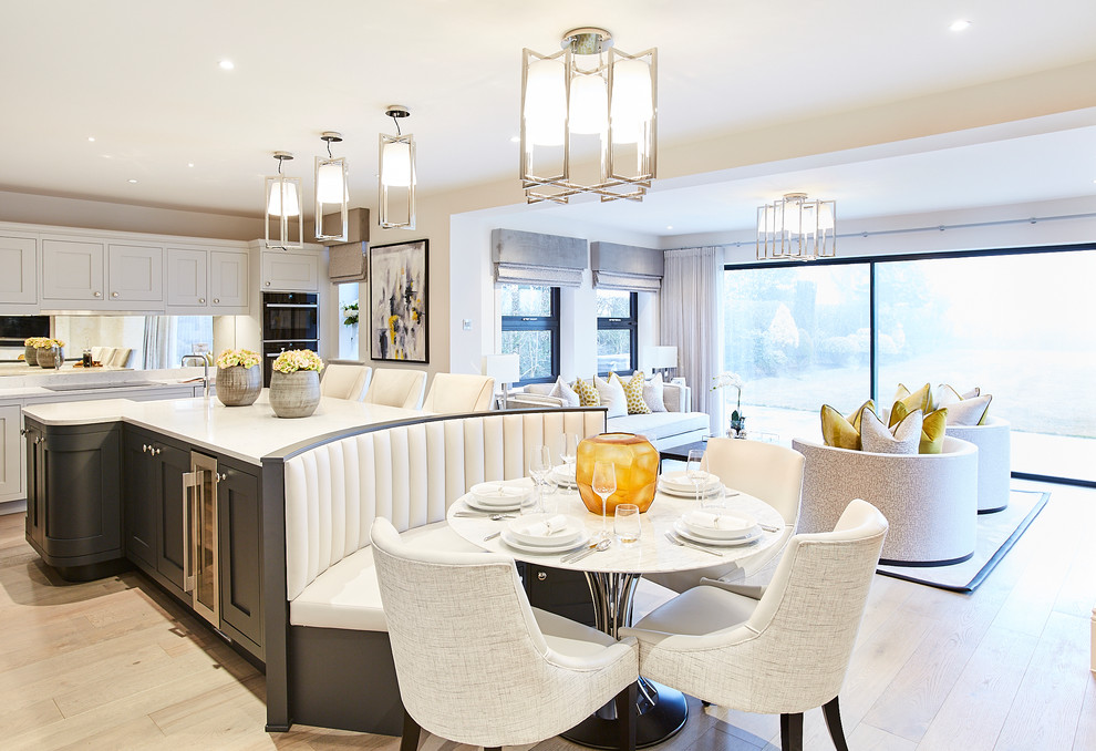 Large trendy light wood floor and beige floor eat-in kitchen photo in Cheshire with white backsplash
