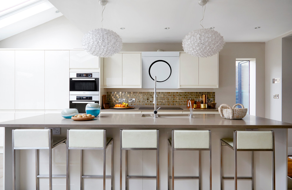 Immagine di un cucina con isola centrale contemporaneo con lavello sottopiano, ante lisce, ante beige, paraspruzzi a effetto metallico e paraspruzzi con piastrelle di metallo