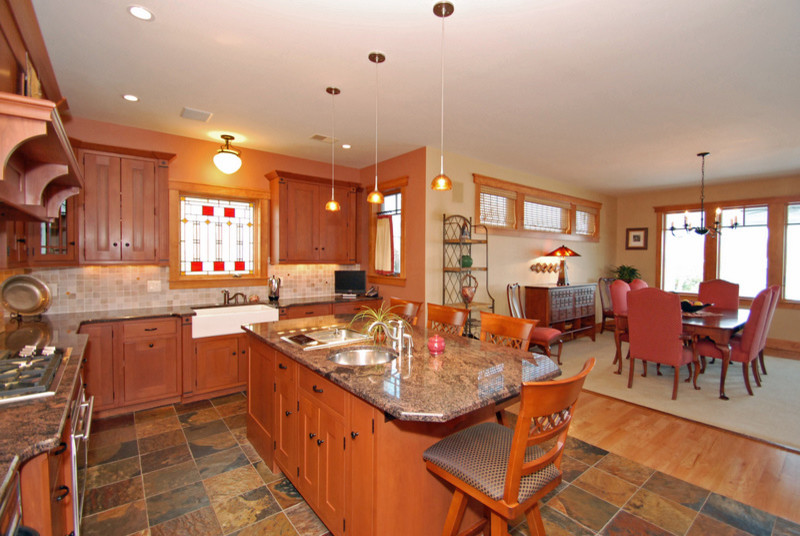 Immagine di un cucina con isola centrale stile americano con lavello stile country, top in granito, elettrodomestici in acciaio inossidabile e pavimento in ardesia