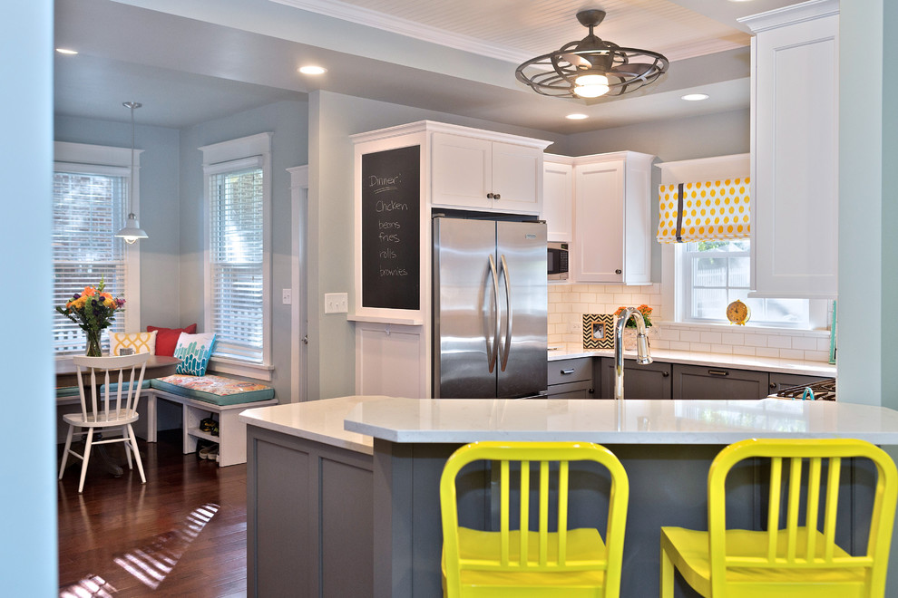 Klassische Küche mit Landhausspüle, Schrankfronten im Shaker-Stil, grauen Schränken, Rückwand aus Metrofliesen und braunem Holzboden in St. Louis