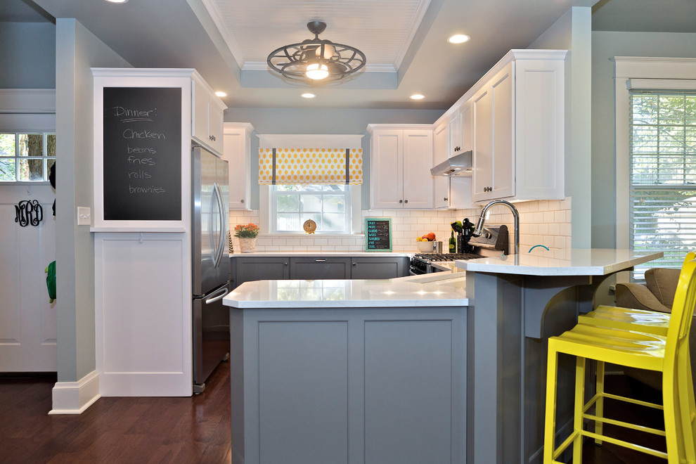 Klassische Küche mit Landhausspüle, Schrankfronten im Shaker-Stil, weißen Schränken, Rückwand aus Metrofliesen und braunem Holzboden in St. Louis