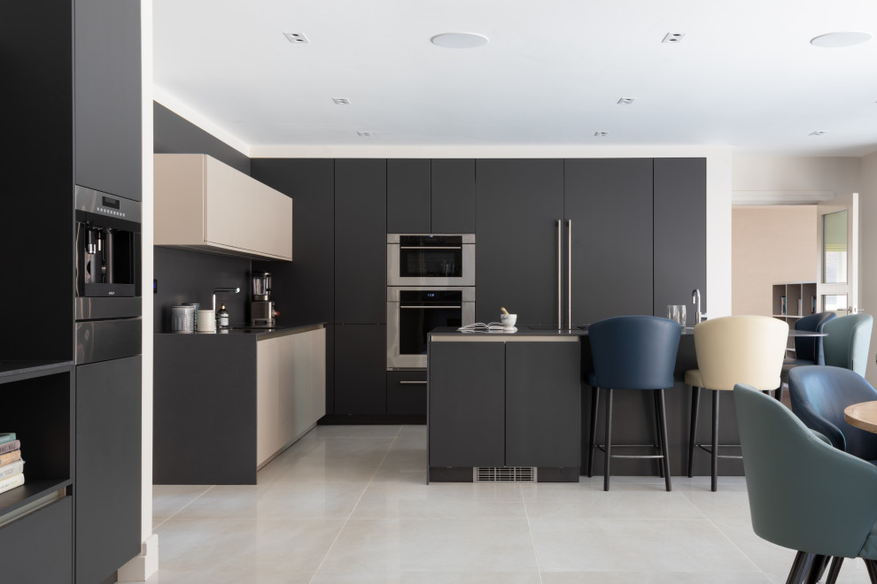 Inspiration for a large contemporary l-shaped kitchen/diner in Hertfordshire with an integrated sink, quartz worktops, black splashback, porcelain flooring, an island, beige floors, black worktops, flat-panel cabinets, black cabinets and stainless steel appliances.
