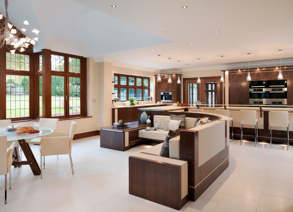 Open concept kitchen - large contemporary limestone floor open concept kitchen idea in Cambridgeshire with flat-panel cabinets, dark wood cabinets, quartzite countertops, an island and an undermount sink