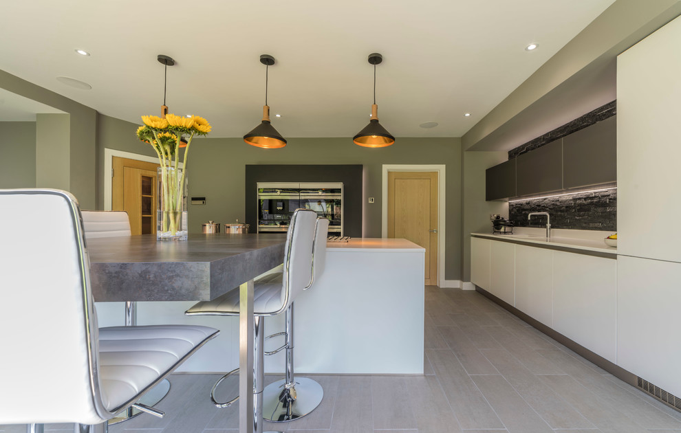 This is an example of a modern kitchen in Manchester with an island.