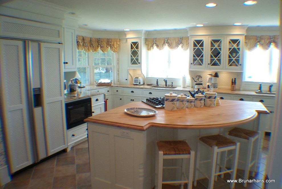 Mid-sized elegant l-shaped travertine floor enclosed kitchen photo in Bridgeport with beaded inset cabinets, white cabinets, wood countertops, paneled appliances, an island, an undermount sink, white backsplash and porcelain backsplash