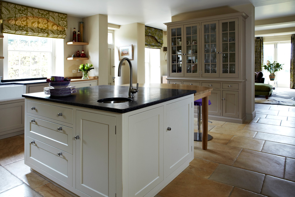 Geschlossene, Zweizeilige, Große Klassische Küche mit Einbauwaschbecken, Schrankfronten mit vertiefter Füllung, weißen Schränken, Granit-Arbeitsplatte, Terrakottaboden und Kücheninsel in Dorset