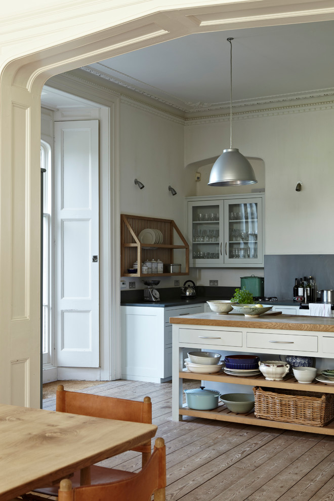 Zweizeilige, Große Landhausstil Wohnküche mit flächenbündigen Schrankfronten, beigen Schränken, Arbeitsplatte aus Holz, Küchenrückwand in Blau, Küchengeräten aus Edelstahl, hellem Holzboden und Kücheninsel in Dorset