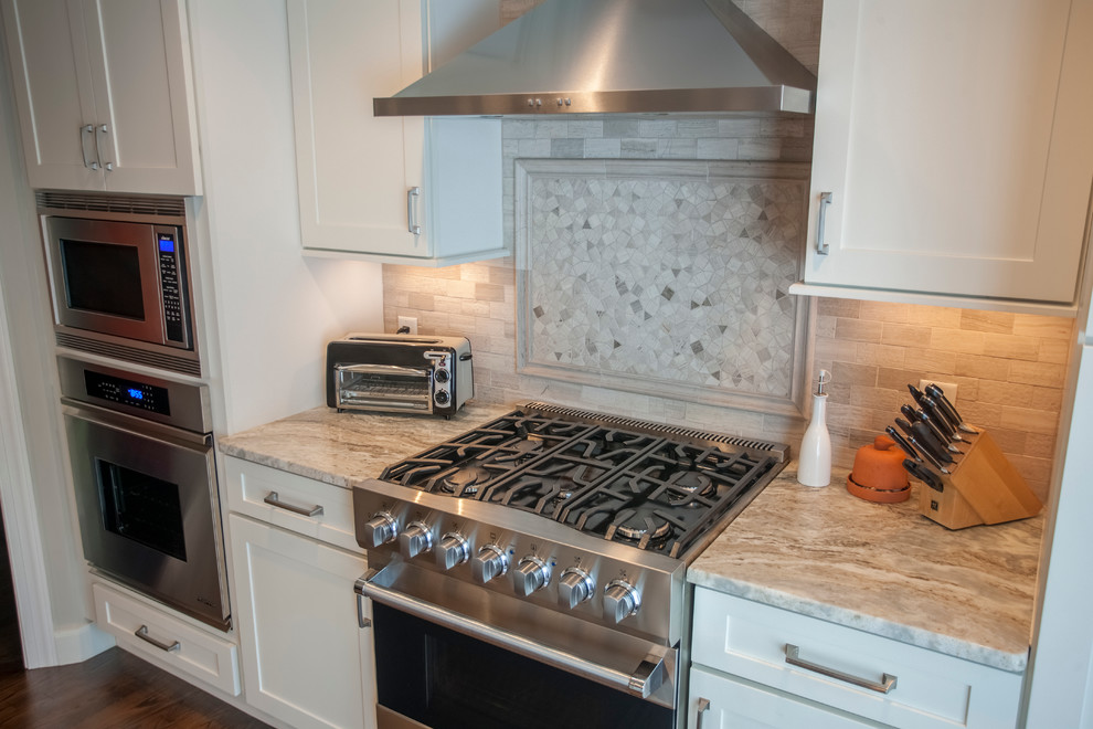 Foto di una cucina chic di medie dimensioni con lavello da incasso, ante a filo, elettrodomestici in acciaio inossidabile e parquet scuro