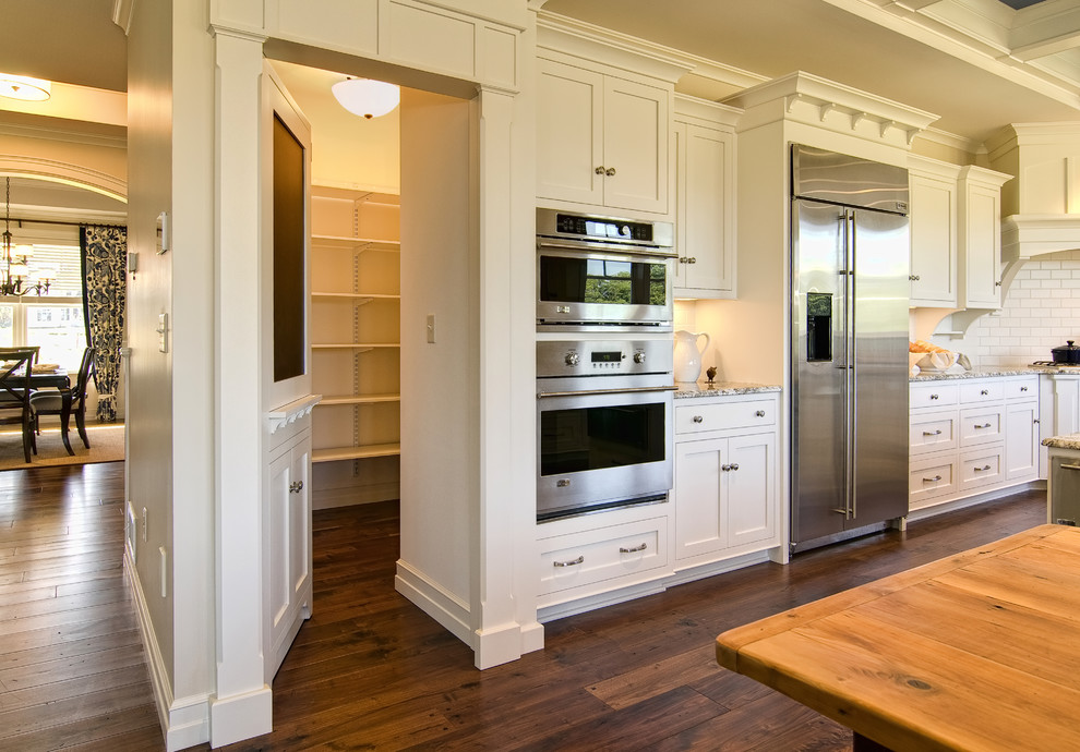 Example of a classic kitchen design in Other with stainless steel appliances and subway tile backsplash