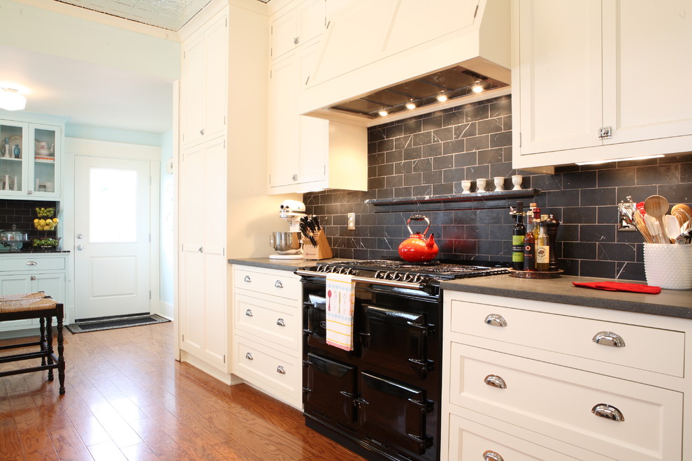 Источник вдохновения для домашнего уюта: кухня среднего размера в стиле кантри с с полувстраиваемой мойкой (с передним бортиком), черным фартуком и паркетным полом среднего тона