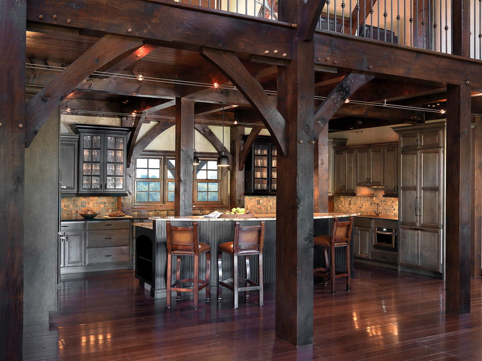 Bild på ett stort rustikt kök, med en undermonterad diskho, luckor med upphöjd panel, grå skåp, granitbänkskiva, flerfärgad stänkskydd, stänkskydd i stenkakel, rostfria vitvaror, mellanmörkt trägolv och en köksö