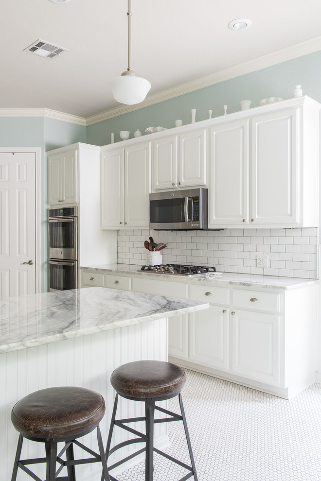 Mid-sized country l-shaped porcelain tile eat-in kitchen photo in Austin with an undermount sink, raised-panel cabinets, white cabinets, quartzite countertops, white backsplash, subway tile backsplash, stainless steel appliances and a peninsula