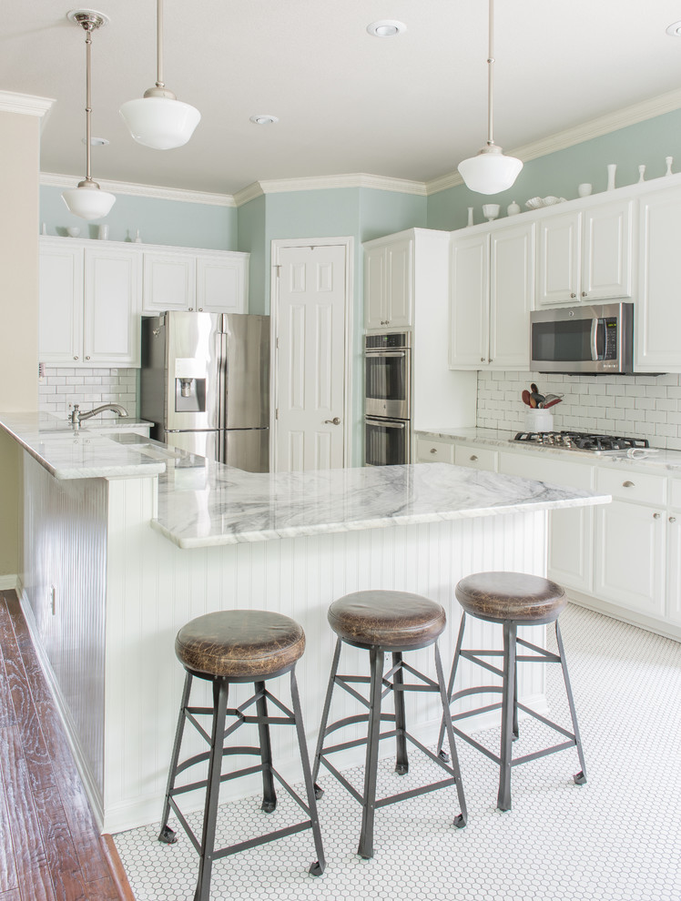 Mid-sized country l-shaped porcelain tile eat-in kitchen photo in Austin with an undermount sink, raised-panel cabinets, white cabinets, quartzite countertops, white backsplash, subway tile backsplash, stainless steel appliances and a peninsula