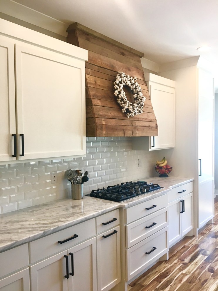 This is an example of a country kitchen in Nashville with shaker cabinets, white cabinets and engineered stone countertops.