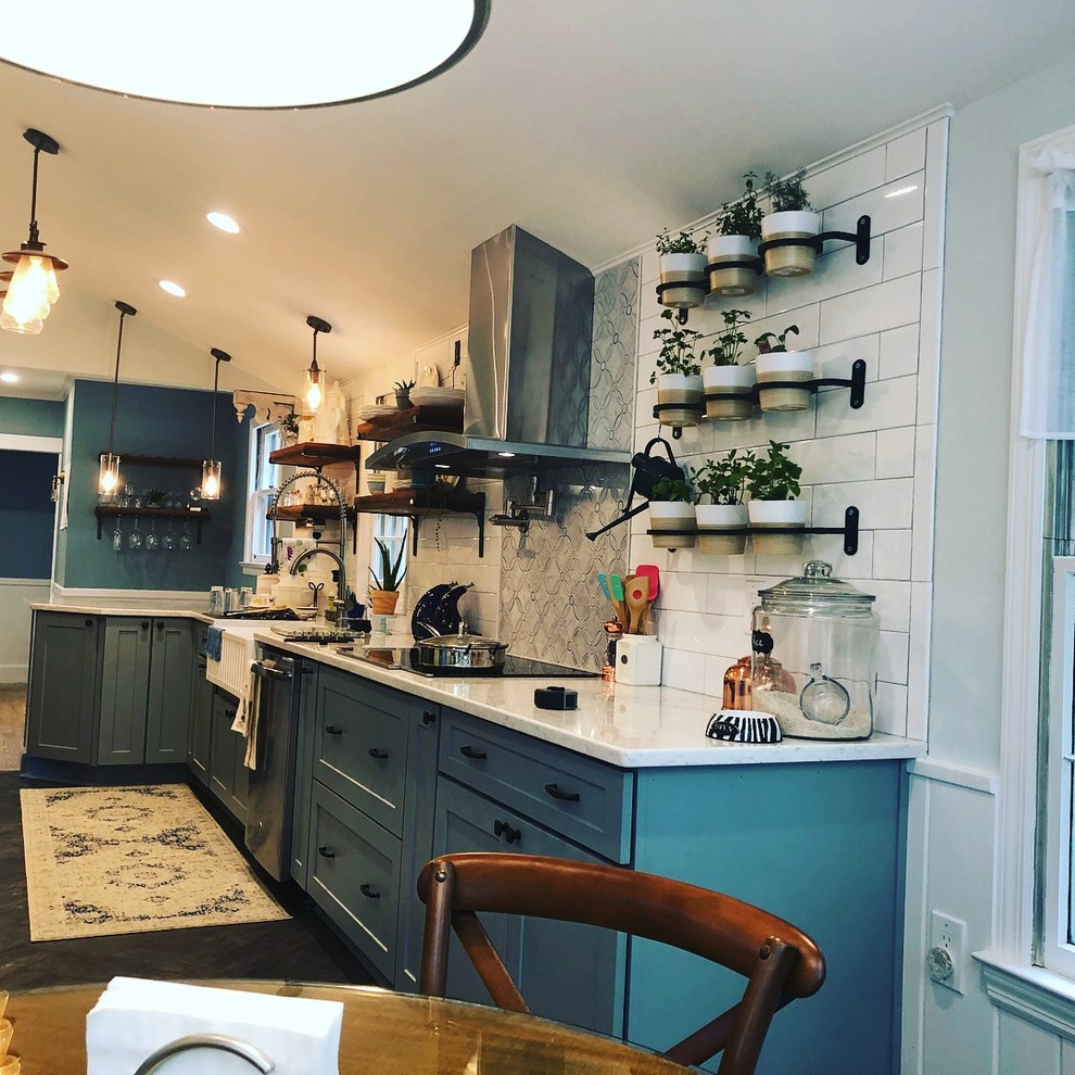 Design ideas for a medium sized farmhouse l-shaped kitchen/diner in New York with a belfast sink, raised-panel cabinets, engineered stone countertops, white splashback, ceramic splashback, stainless steel appliances, ceramic flooring, grey floors and grey worktops.