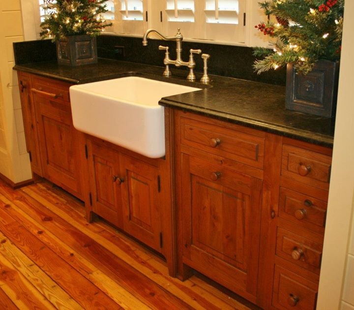 Foto på ett stort lantligt kök, med en rustik diskho, luckor med profilerade fronter, skåp i mellenmörkt trä, granitbänkskiva, svart stänkskydd, stänkskydd i sten, integrerade vitvaror, mellanmörkt trägolv och en köksö