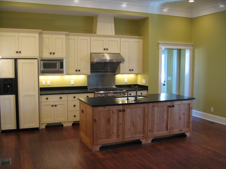 Farmhouse kitchen in Charleston with a submerged sink, shaker cabinets, white cabinets, stainless steel appliances, dark hardwood flooring and an island.