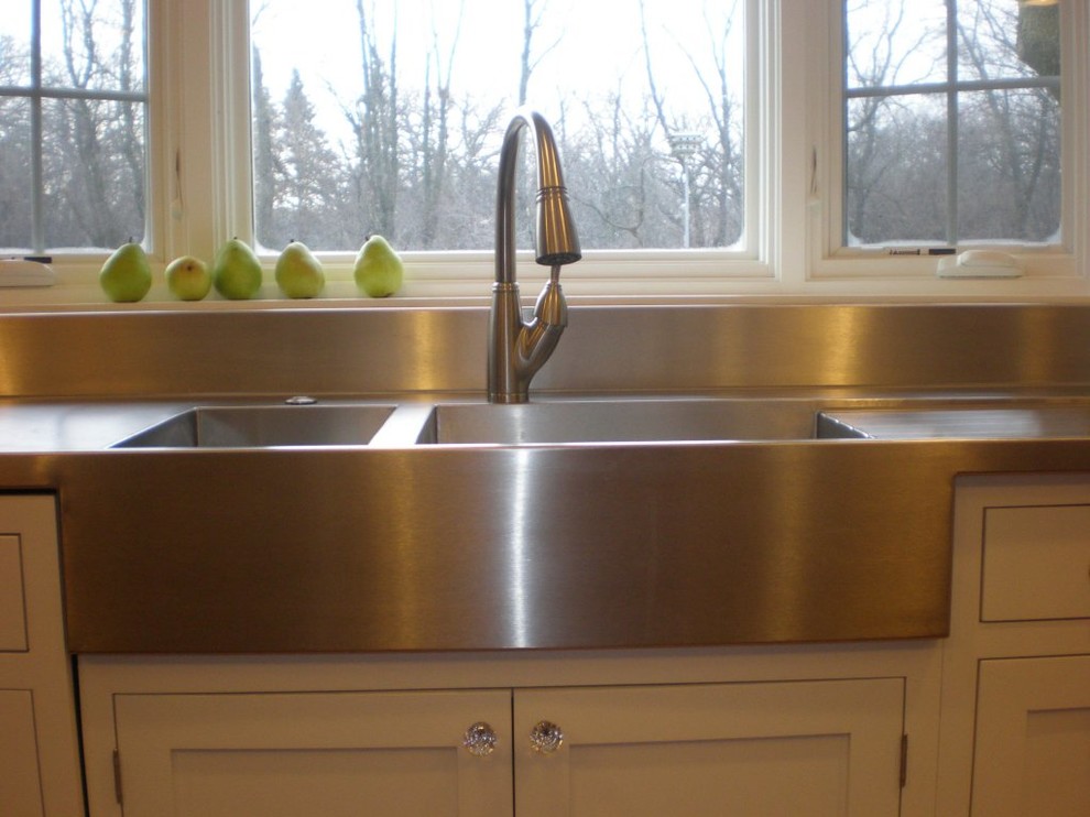 Example of a farmhouse eat-in kitchen design in Chicago with a farmhouse sink, white cabinets and stainless steel countertops