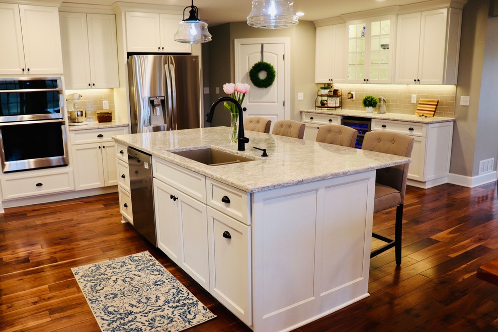 Example of a huge farmhouse medium tone wood floor and multicolored floor eat-in kitchen design in New York with an undermount sink, shaker cabinets, white cabinets, quartz countertops, white backsplash, ceramic backsplash, stainless steel appliances, an island and white countertops