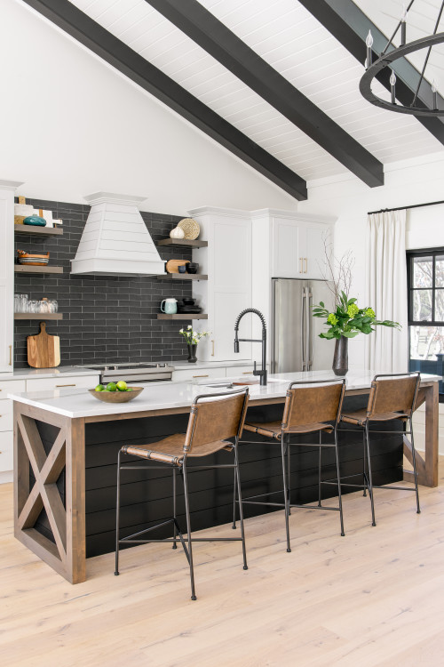 Black Kitchen Island with Wooden Countertop and White Farmhouse Kitchen Cabinets with Black Backsplash